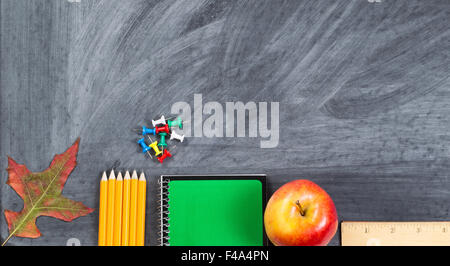 Les fournitures scolaires plus feuille d'automne sur le tableau. Concept Retour à l'école pour l'automne saison avec beaucoup d'espace de copie. Banque D'Images