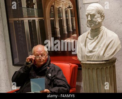 Homme portant des lunettes, en train de lire dans le Boston Athenæum Banque D'Images