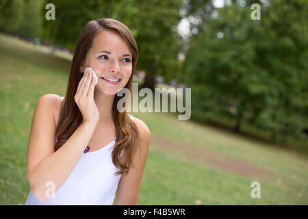 Jeune femme avec son visage nettoyant visage maquillage pads Banque D'Images