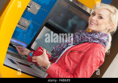 Beautiful smiling woman en utilisant un guichet automatique bancaire Banque D'Images