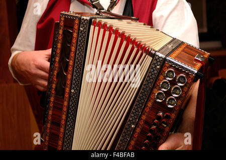 L'homme en costume traditionnel joue de l'harmonica Banque D'Images