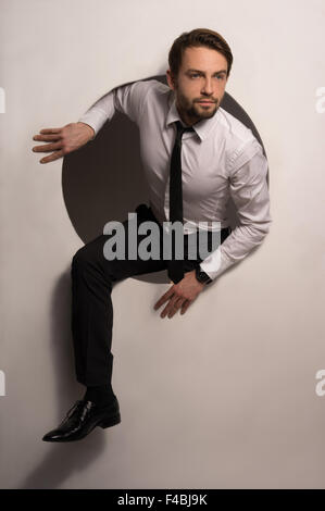 Businessman climbing out d'un trou circulaire Banque D'Images