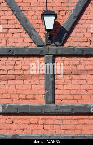 La lanterne se bloque sur un mur de brique rouge. Grumes de pin en bois sont fixées sous la forme de Y et H de lettres. Notion de secret. Sunny d Banque D'Images