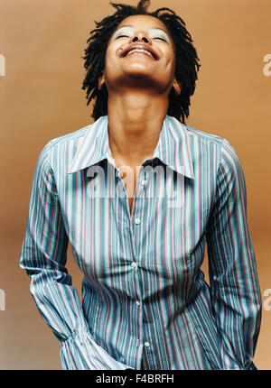 Portrait de femme à la peau sombre dans une chemise rayée. Banque D'Images