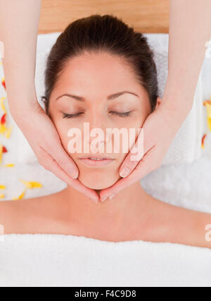 Dark-haired woman beauté avoir un massage du visage Banque D'Images