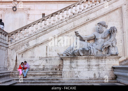 Les gens à côté de l'allégorie de la Rome antique de Nil par Matteo di Castello sur la façade du palais des sénateurs sur la Piazza del Campidog Banque D'Images