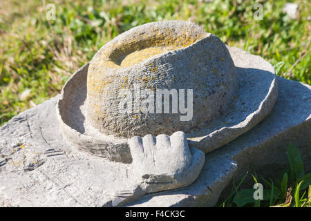 Main tenant la sculpture en pierre de chapeau au parc de sculpture de la carrière de Tout, île de Portland, Dorset Royaume-Uni en octobre Banque D'Images
