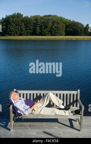 Un homme dort sur un banc. Banque D'Images