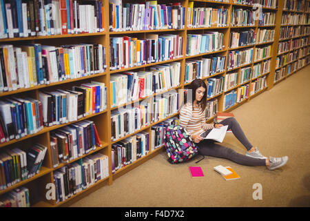 Les jeunes femmes se concentrant sur des études tout en étant assis dans la bibliothèque Banque D'Images