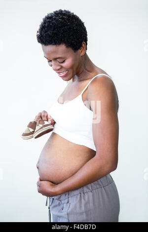 Pregnant woman holding small shoes Banque D'Images