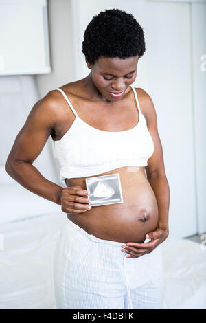 Pregnant woman holding ultrasound par son estomac Banque D'Images