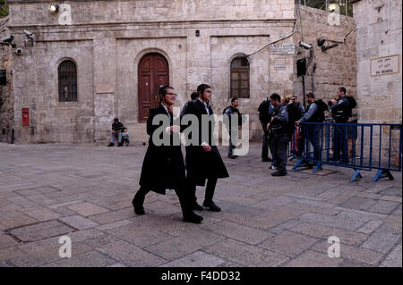 Les juifs religieux ultra orthodoxes traversent la rue Al Wad que les Israéliens appellent Haggai dans le quartier musulman, la vieille ville de Jérusalem Israël Banque D'Images