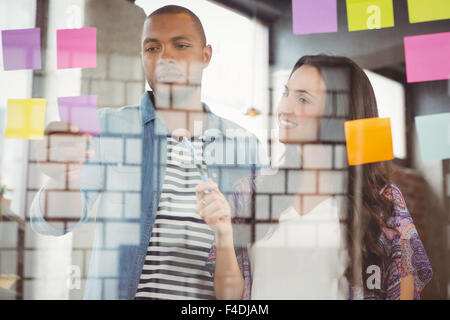 Woman pointing at sticky note in office Banque D'Images