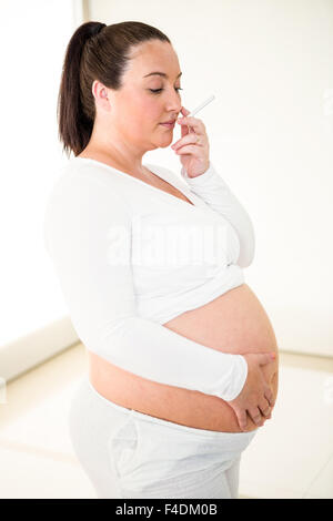 Cute pregnant woman holding cigarette Banque D'Images