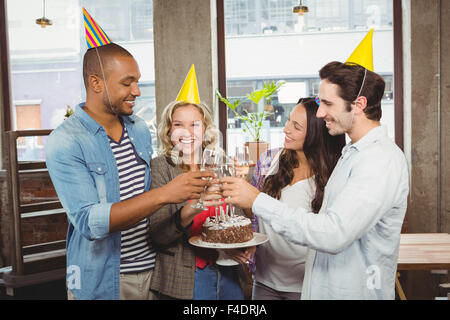 Collègues appréciant avec champagne et gâteau d'anniversaire Banque D'Images