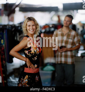 Femme d'essayer une robe, un homme est en train de la regarder. Banque D'Images