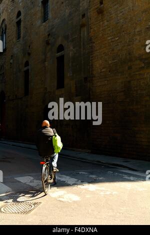 Homme d'une bicyclette à travers les rues de Florence Italie Banque D'Images