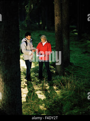 Couple scandinave dans la forêt de la lecture d'un site, Kolmarden, océan, la Suède. Banque D'Images