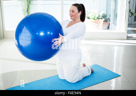 Pregnant woman exercising on ball Banque D'Images