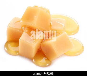 Bonbons au caramel sucré sur le fond blanc. Banque D'Images