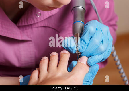 Pédicure maître façonne l'ONGLES ET CUTICULES. Manucure matériel. Concept les soins du corps. Banque D'Images