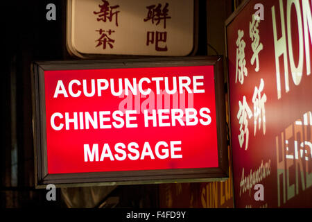 Chinatown London England UK signe devant les boutiques la nuit publicité médecine traditionnelle chinoise y compris l'acupuncture et de l'herbe Banque D'Images