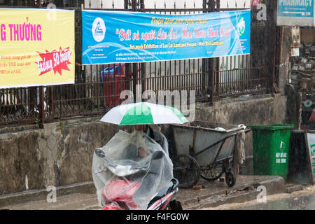 Sapa ou Sa Pa est une ville frontière au nord-ouest du Vietnam, de coups ici dans la saison humide pluie rider a parasol au-dessus de scooter Banque D'Images