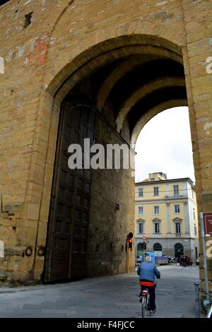 Vélo homme au travers du portail des anciens murs de la ville de Florence Italie Banque D'Images