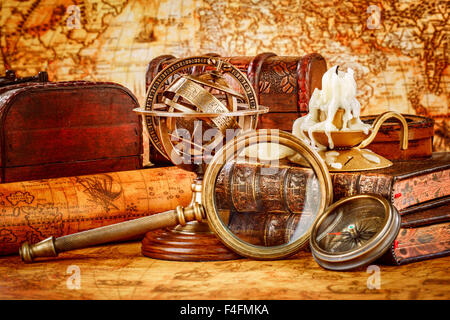 Vintage still life. Vintage loupe réside, montre de poche, livre ancien et sphère armillaire sur une ancienne carte du monde en 1565. Banque D'Images