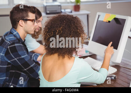 Businesswoman pointing at computer during meeting Banque D'Images
