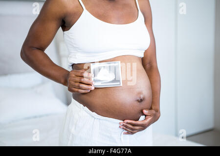 Pregnant woman holding ultrasound par son estomac Banque D'Images