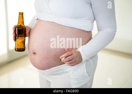 Cute pregnant woman holding cigarette et bière Banque D'Images