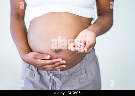 Pregnant woman holding pills dans sa main Banque D'Images