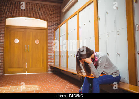 Inquiets student sitting in locker room Banque D'Images