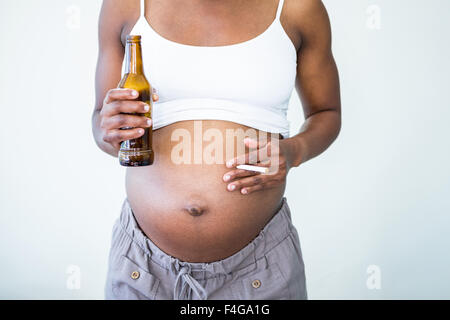 Pregnant woman holding l'alcool et les cigarettes Banque D'Images