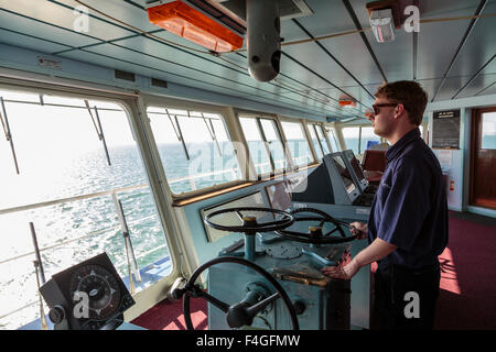 Un officier à la tête du pont d'un ferry traversant le Solent entre Portsmouth et l'île de Wight, Angleterre Royaume-uni Banque D'Images