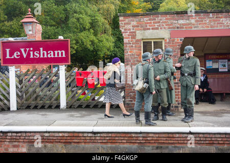 Pickering, North Yorkshire, UK. 17 octobre, 2015. La guerre et de l'annuel Pickering 40's Week-end attire des milliers, avec la Première Guerre mondiale 2 l'histoire de vie des camps et des reconstitutions de bataille amomg les attractions. Sur la photo : Levisham, près de Pickering, North Yorkshire Moors sur la ligne de chemin de fer, est converti en un village français occupés. Même les signes staition ont été changées pour le Visham pour le week-end. Soldat allemand sur la plate-forme en photo Banque D'Images