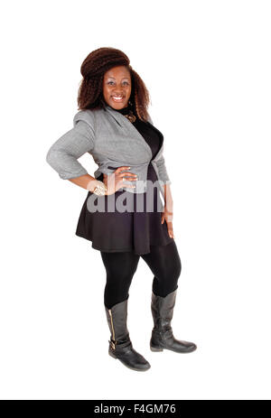 Une photo d'une jeune femme afro-américaine dans une robe noire et gris veste et bottes, isolés pour white ba Banque D'Images