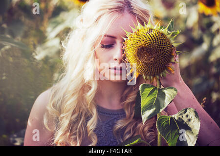 Belle blonde femme dans un champ de tournesol Banque D'Images