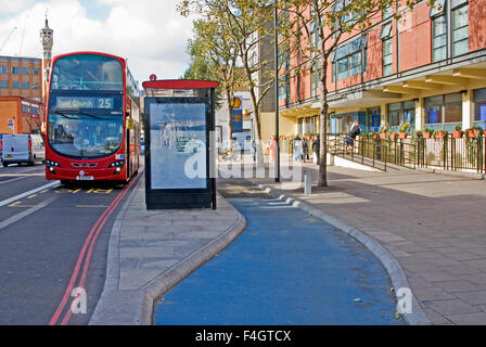 Un double pont moderne rouge passe London bus un arrêt de bus avec une nouvelle piste cyclable à Whitechapel, contournement de l'Est de Londres. L'investissement dans les infrastructures cyclables. Banque D'Images