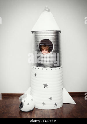 Heureux l'enfant habillé en costume d'astronaute en jouant avec la fusée. Banque D'Images