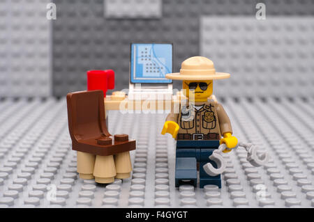 Shérif Lego playmobil - 5116 - moto avec des menottes en arrestation de son lieu de travail avec ordinateur et tasse. Banque D'Images