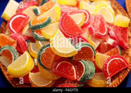 Les gelées ou les guimauves colorés avec du sucre dans un bol sur la table de couleur bleu. Selective focus Banque D'Images