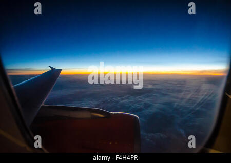 Vue du lever du soleil à travers une fenêtre d'avion easyJet Airbus A320. Avion de ligne au-dessus de l'Europe. Nouvelle aube sur le continent européen Banque D'Images