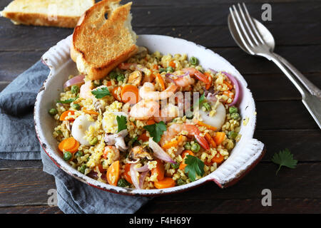 Boulgour avec fruits de mer grillés dans vieille casserole Banque D'Images