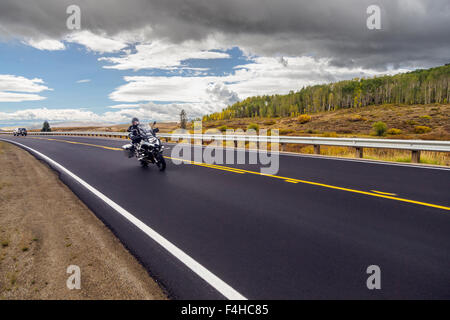 Pilote moto sur route pavée ; l'autoroute 40 Nord ; le centre du Colorado, USA Banque D'Images