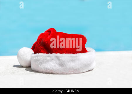 Santa Claus hat proche piscine avec de l'eau turquoise Banque D'Images