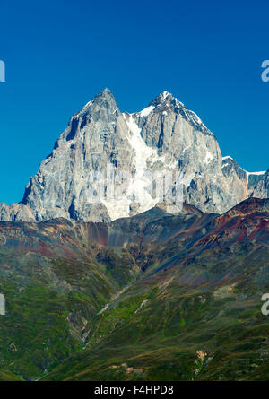 Les deux sommets du Mont Ushba (4710m) dans la région de Svaneti des montagnes du Caucase dans le nord-ouest de la Géorgie. Banque D'Images