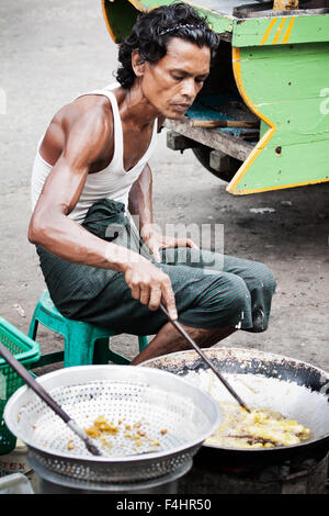 Street Photography Photo de l'homme birmane la friture d'aliments de rue dans la rue au Myanmar. restauration rapide, Snack food bon marché d'une petite entreprise Banque D'Images