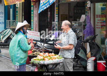 Visiteur touristique de l'ouest l'achat de fruits vietnamiens une dame avec location à Hanoi la vieille capitale,Vietnam, Banque D'Images